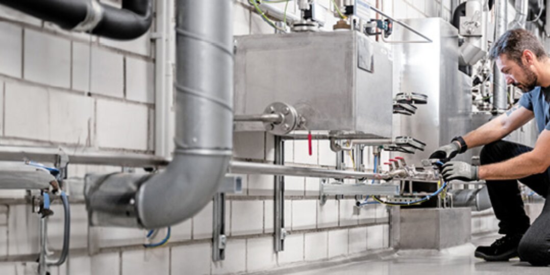 Dussmann building technician repairs pipe